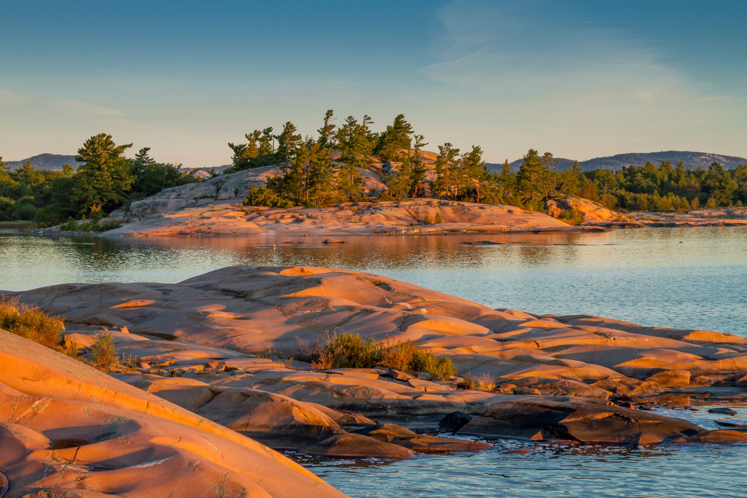 Rocks and trees on Georgian Bay during sunset.